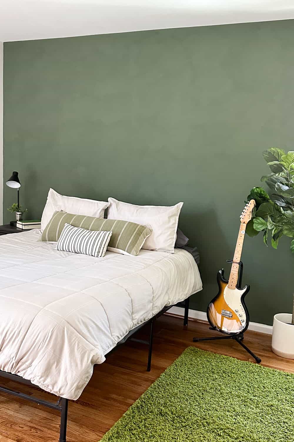 Bedroom with green limewashed accent wall