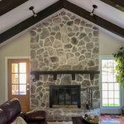 A living room with a stone fireplace and a couch.