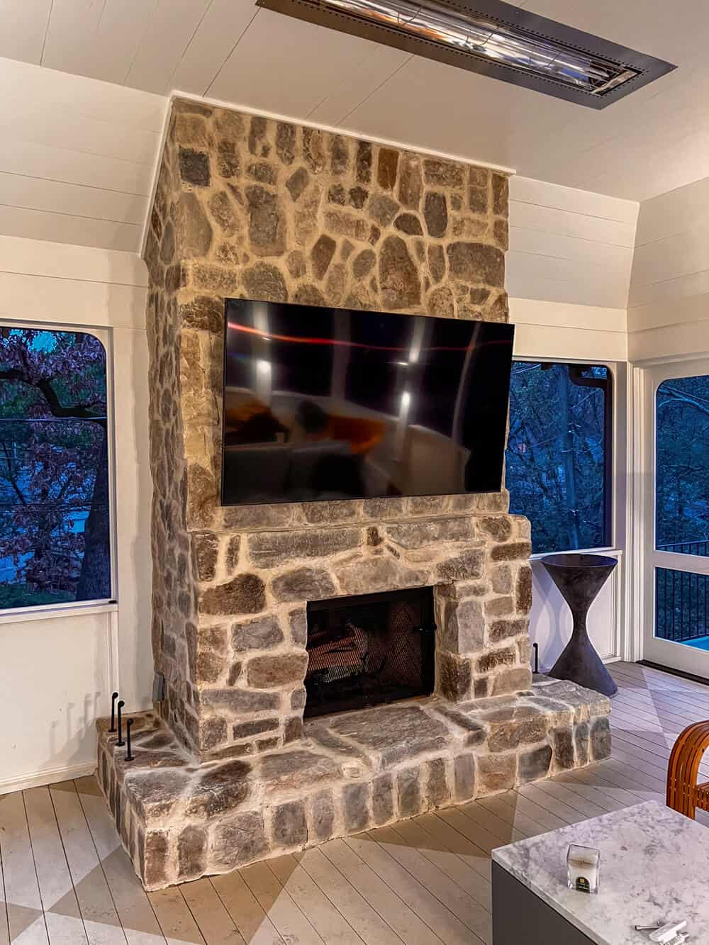 A stone fireplace with a tv mounted on it.